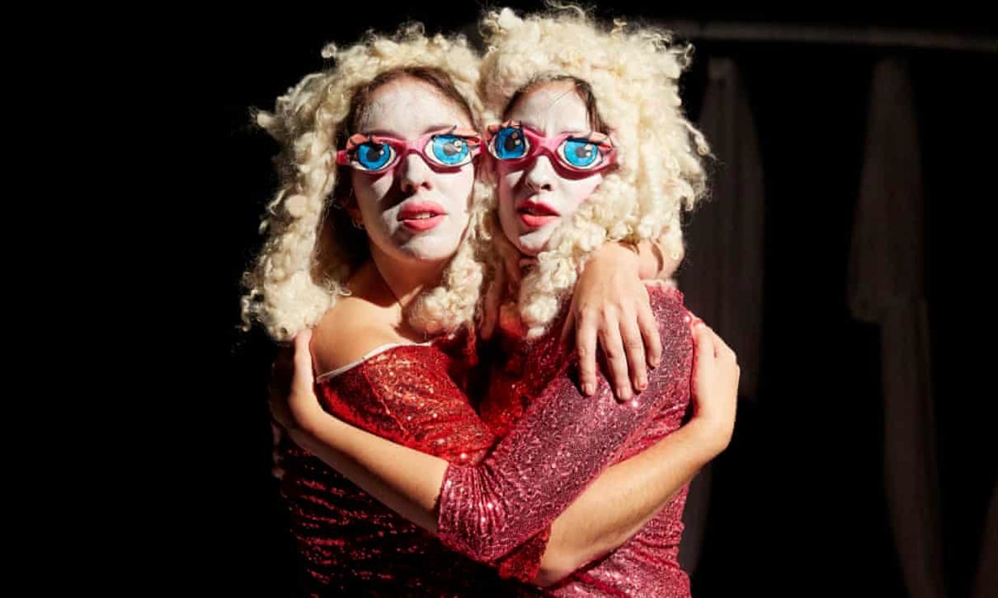 Louise and Rebecca of shit theatre embrace wearing matching wigs and glittery tops Louise and Rebecca of shit theatre embrace wearing matching wigs and glittery tops