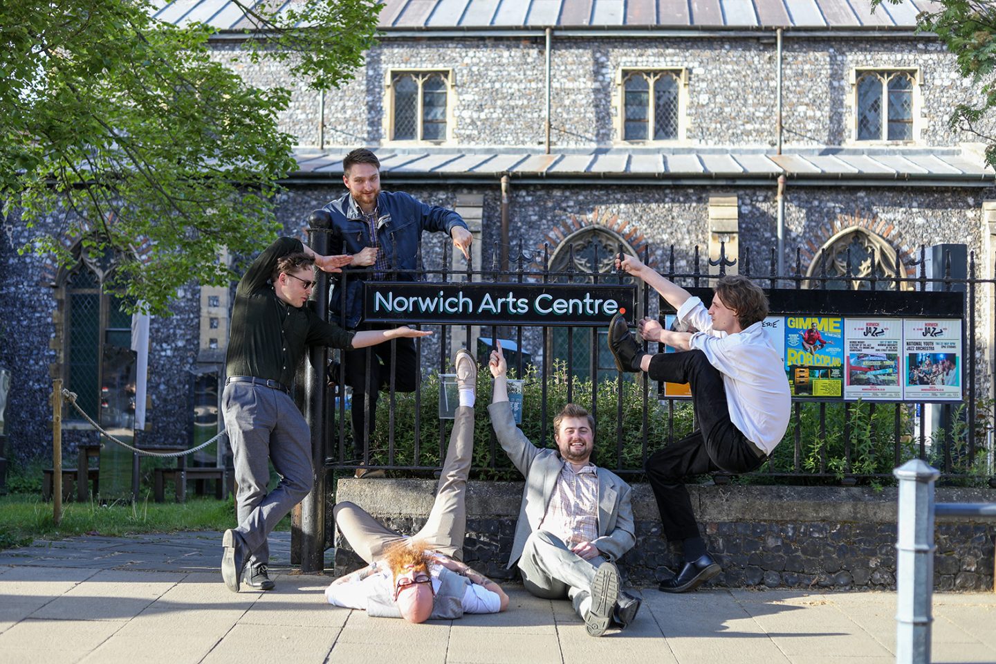 A group of five people gathered around and pointing at the sign for Norwich Arts Centre, a venue in a 14 century Flint former Church. A group of five people gathered around and pointing at the sign for Norwich Arts Centre, a venue in a 14 century Flint former Church.