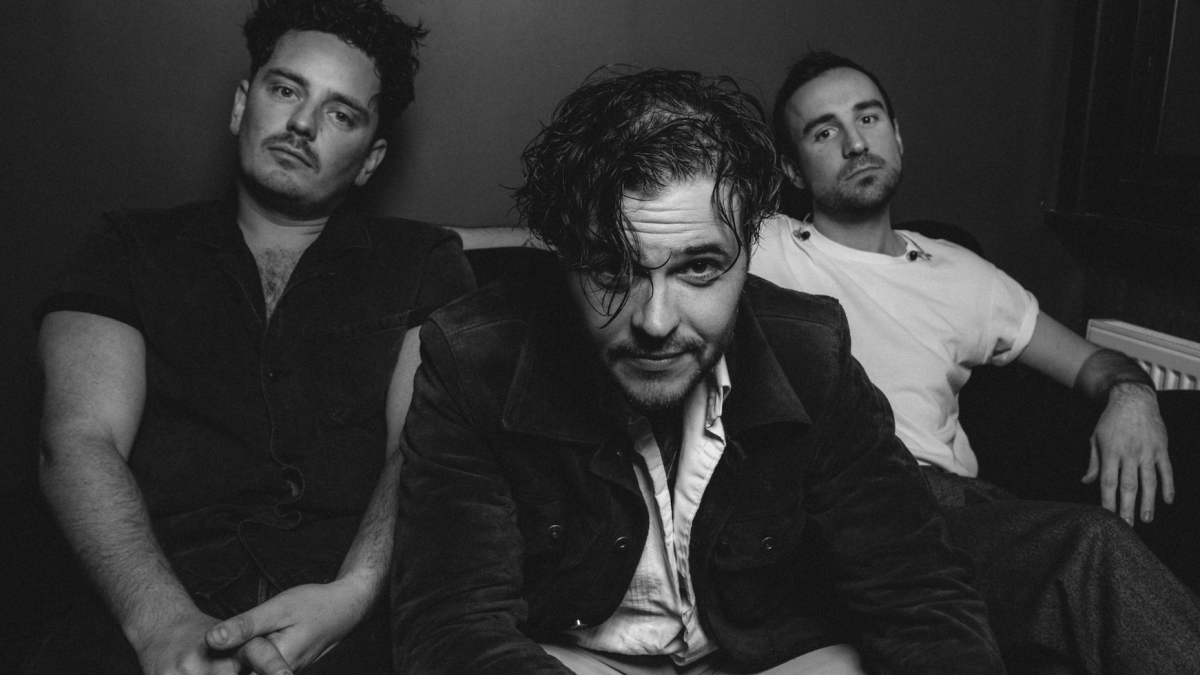 Black and white photo of three people sitting on a couch