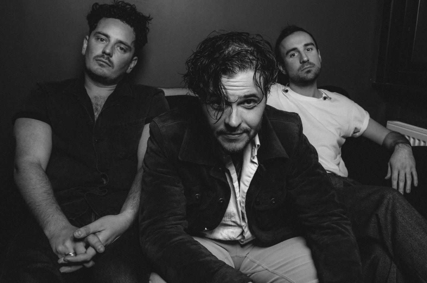 Black and white photo of three people sitting on a couch Black and white photo of three people sitting on a couch