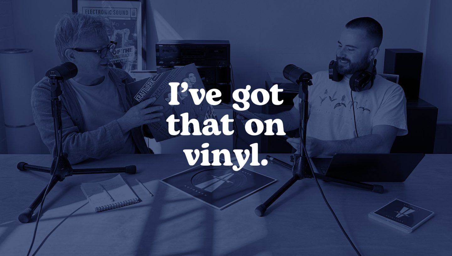 Two people sit at a table with microphones, discussing vinyl records during a podcast. One holds a Kraftwerk album while the other smiles. The text “I’ve got that on vinyl.” is displayed over the image. Two people sit at a table with microphones, discussing vinyl records during a podcast. One holds a Kraftwerk album while the other smiles. The text “I’ve got that on vinyl.” is displayed over the image.