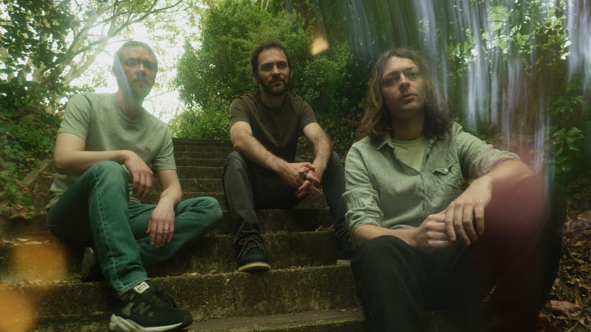 Three men sit on stone steps